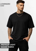 A young man wearing black oversized tshirt front view